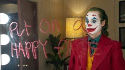 joker looks into a mirror with writing telling him to put on a happy face